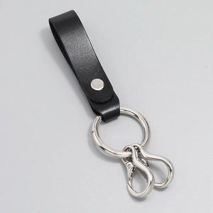 Detail of black grained leather keychain with silver rivets and dual metal spring hooks