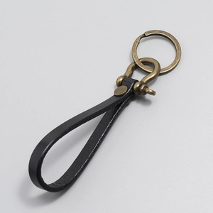 Detailed view of black vintage leather keychain with bronze horseshoe buckle and ring