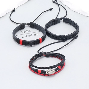 Detail of woven leather bracelet set with star charm and metal turtle ornament