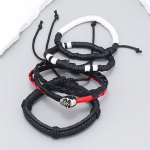 Detail of bohemian four-piece leather bracelet set featuring skull charm and braided textures