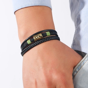 Multilayer leather bracelet with vintage bronze tube and green thread on male wrist