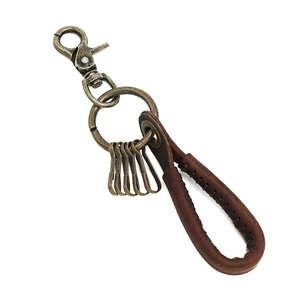 Vintage brown leather car keychain with bronze hardware and four hooks on white background