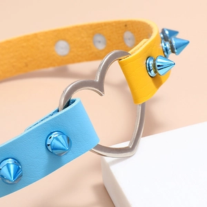 Detail of punk heart choker with blue metallic spikes and yellow-blue leather band