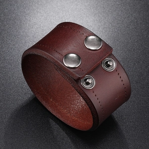 Detail view of dark brown punk leather bracelet with silver metal snap buttons