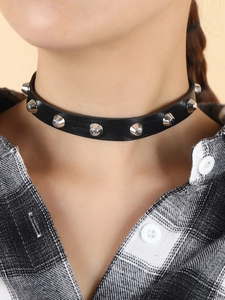 Close-up of punk black leather choker featuring silver cone rivets on a model neck