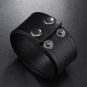 Close-up of black cowhide leather cuff with silver adjustable snap buttons and stitching