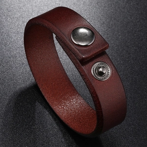 Detail of red-brown vintage leather bracelet with silver metal snap buttons and fine texture