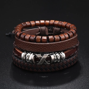 Macro view of four-piece set vintage braided leather bracelets with wooden beads and metal charms