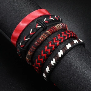 Detail of five multi-layered woven bohemian leather bracelets on a black display stand