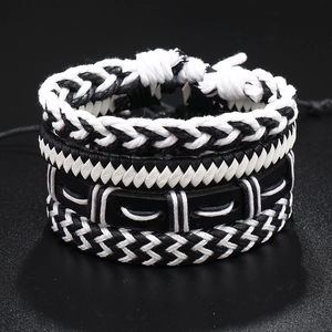 Detail of four-piece punk multilayer leather bracelets with black and white braided cords