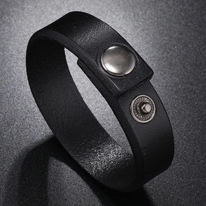 Detail of black leather bracelet with silver snap fasteners and clean cut edges