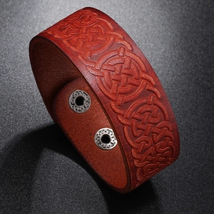 Detail of red-brown leather bracelet with Celtic knot embossing and silver snap buttons