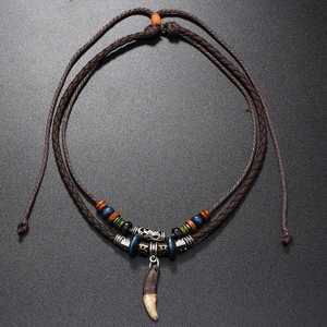 Macro detail of ethnic tribal wolf tooth pendant necklace with colorful wooden beads