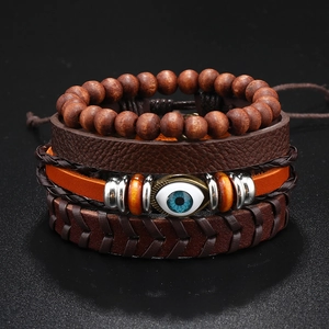 Détail de bracelets en cuir multicouches avec perles en bois et breloque œil bleu