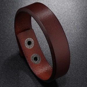 Detail of dark brown leather cuff with two adjustable vintage sunflower metal snaps