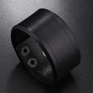 Macro detail of high-quality black leather wristband showing fine stitching and metal snaps