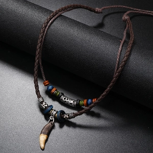 Ethnic vintage layered leather necklace featuring a faux wolf tooth pendant and wood beads