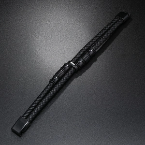 Détail du bracelet en cuir noir tressé à deux rangs avec accents en métal texturé