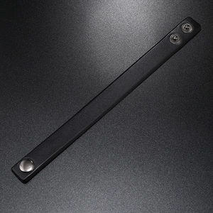 Detailed view of the adjustable snap closure on a black leather punk style bracelet