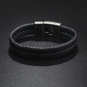 Detail of black woven leather bracelet featuring a vintage matte metal magnetic clasp
