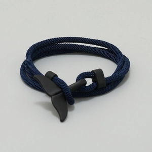 Detail of dark blue nautical rope bracelet with a matte black whale tail clasp