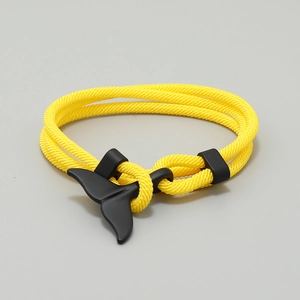 Detail of yellow woven rope bracelet with a matte black whale tail clasp design