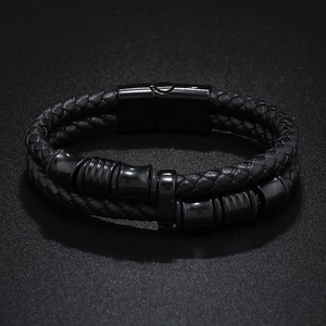 Détail du bracelet multicouche en cuir noir tressé avec perles en métal brillant et fermoir aimanté