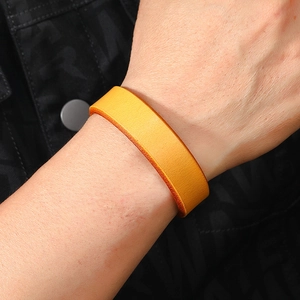 Close-up of bright yellow leather cuff bracelet with fine texture on wrist