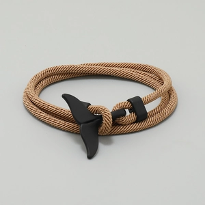 Close-up of brown nylon cord bracelet with a matte black whale tail clasp detail
