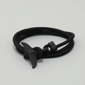 Detail of black woven rope bracelet with matte black whale tail metal fastener