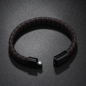 Detail of men's braided leather bracelet with black magnetic clasp and small zircon