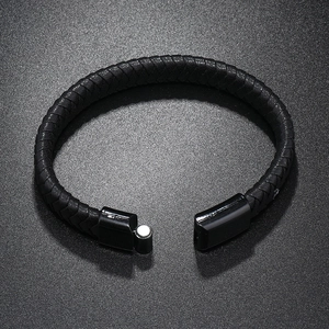 Detailed view of black braided leather bracelet with magnetic metal clasp on stone