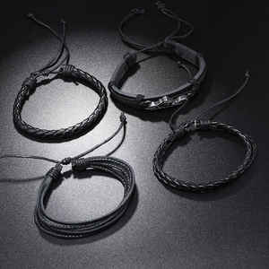 Detailed set of four black braided leather bracelets with vintage punk metal ornaments