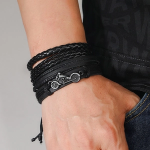Detail of multi-layer braided leather bracelet with vintage motorcycle charm on wrist