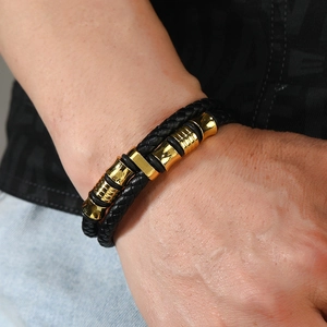 Détail du bracelet en cuir tressé noir pour homme avec accents métalliques dorés