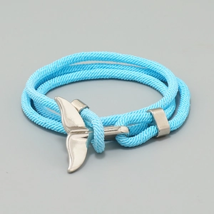 Detailed close-up of the hand-woven blue Milan cord with silver whale tail pendant