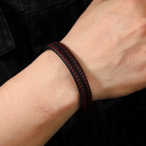 Close-up of black and burgundy braided leather bracelet with magnetic clasp on wrist
