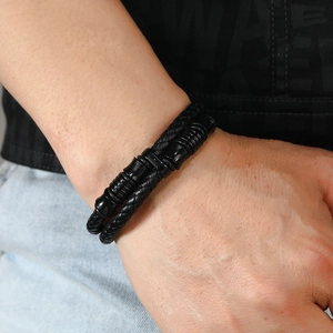 Détail d'un bracelet multicouche en cuir tressé pour homme avec des perles métalliques