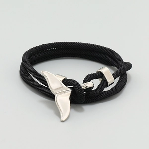 Detail of black woven cord bracelet with silver whale tail hook buckle closure