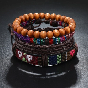Detail of four-piece bohemian braided leather bracelet set with ethnic embroidery and wood beads