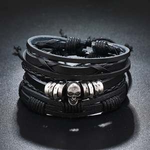 Detailed macro of multi-layer leather bracelet with silver skull charm and metal rings