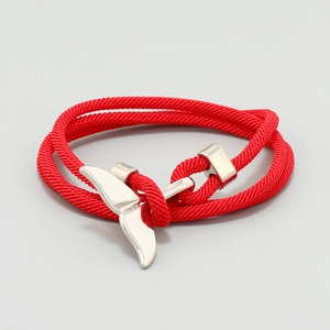 Close-up of red woven cord bracelet with polished silver whale tail metal clasp