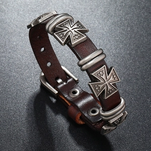Dettaglio del bracciale vintage in pelle marrone con borchie a croce di ferro