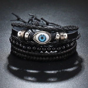 Macro view of multi-layer leather bracelets with an evil eye charm and matte wooden beads