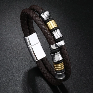 Détail du bracelet en cuir tressé marron avec perles métalliques or et argent et fermoir aimanté
