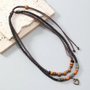 Retro multi-layer woven necklace with heart pendant and wooden beads on stone