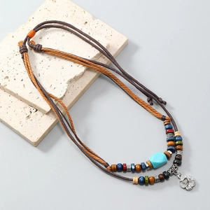 Bohemian multi-layer necklace with turquoise beads and retro flower pendant on stone tiles