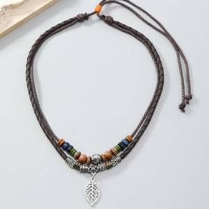 Detail of bohemian layered necklace with colorful wood beads and hollow metal leaf pendant