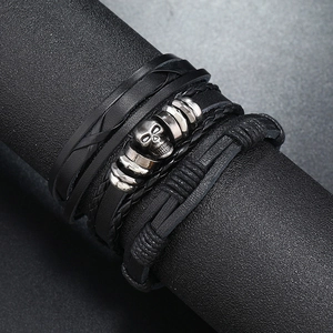Three-piece set of layered leather bracelets featuring a vintage silver skull charm