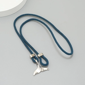 Detailed shot of a silver whale tail pendant on a navy blue braided cord bracelet